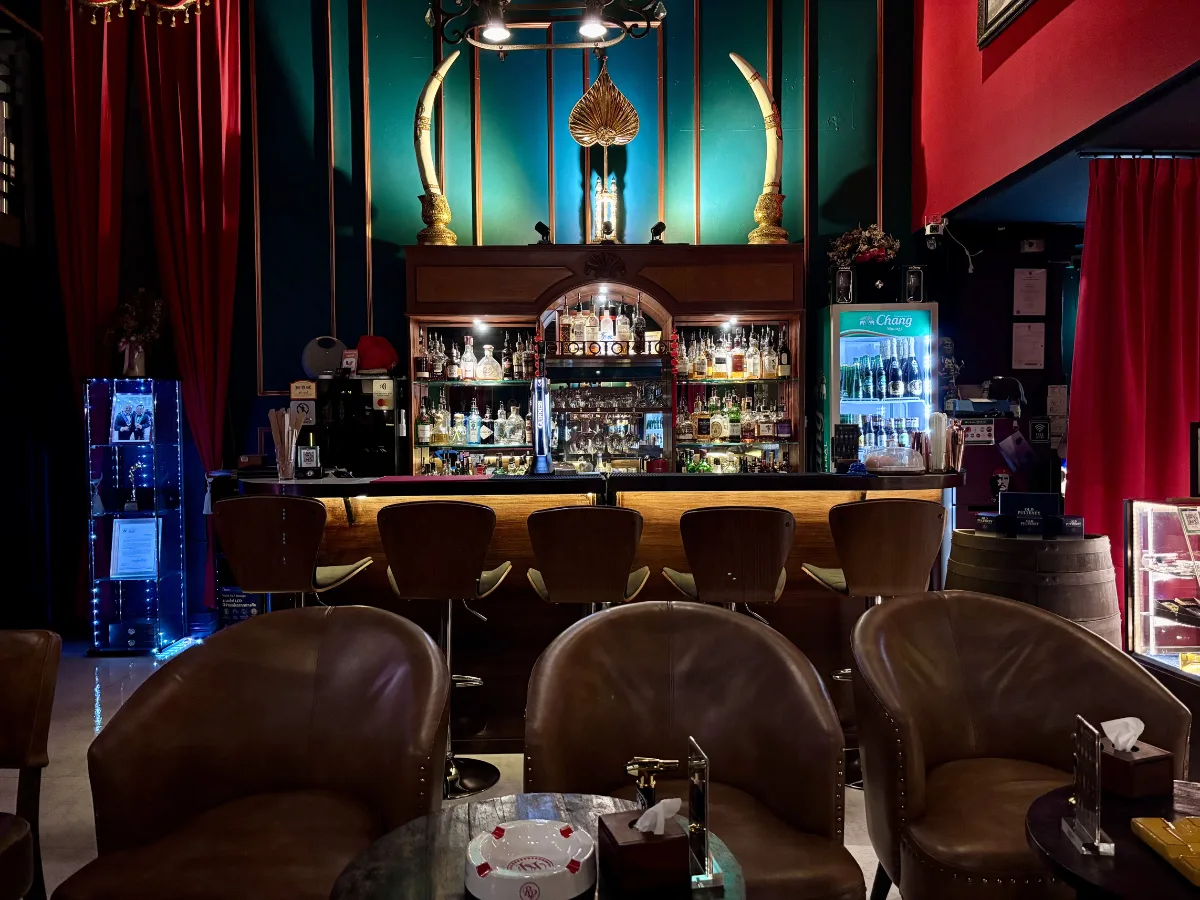 CNX Cigars bar with leather chairs and teal backdrop